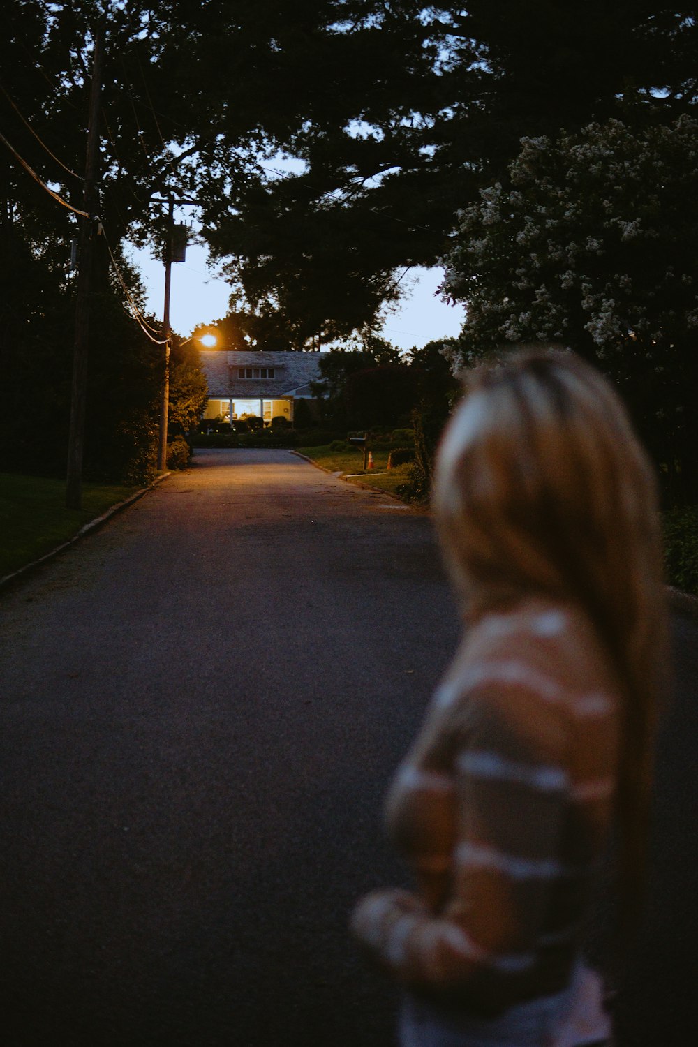 woman in white and blue jacket standing on sidewalk during daytime