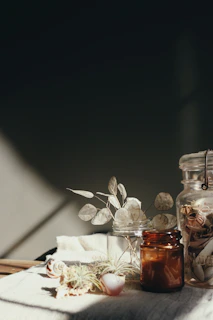 clear glass bottle on white textile