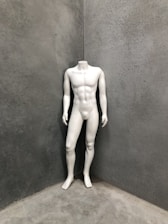 A sleek white mannequin standing in a modern retail display setting.
