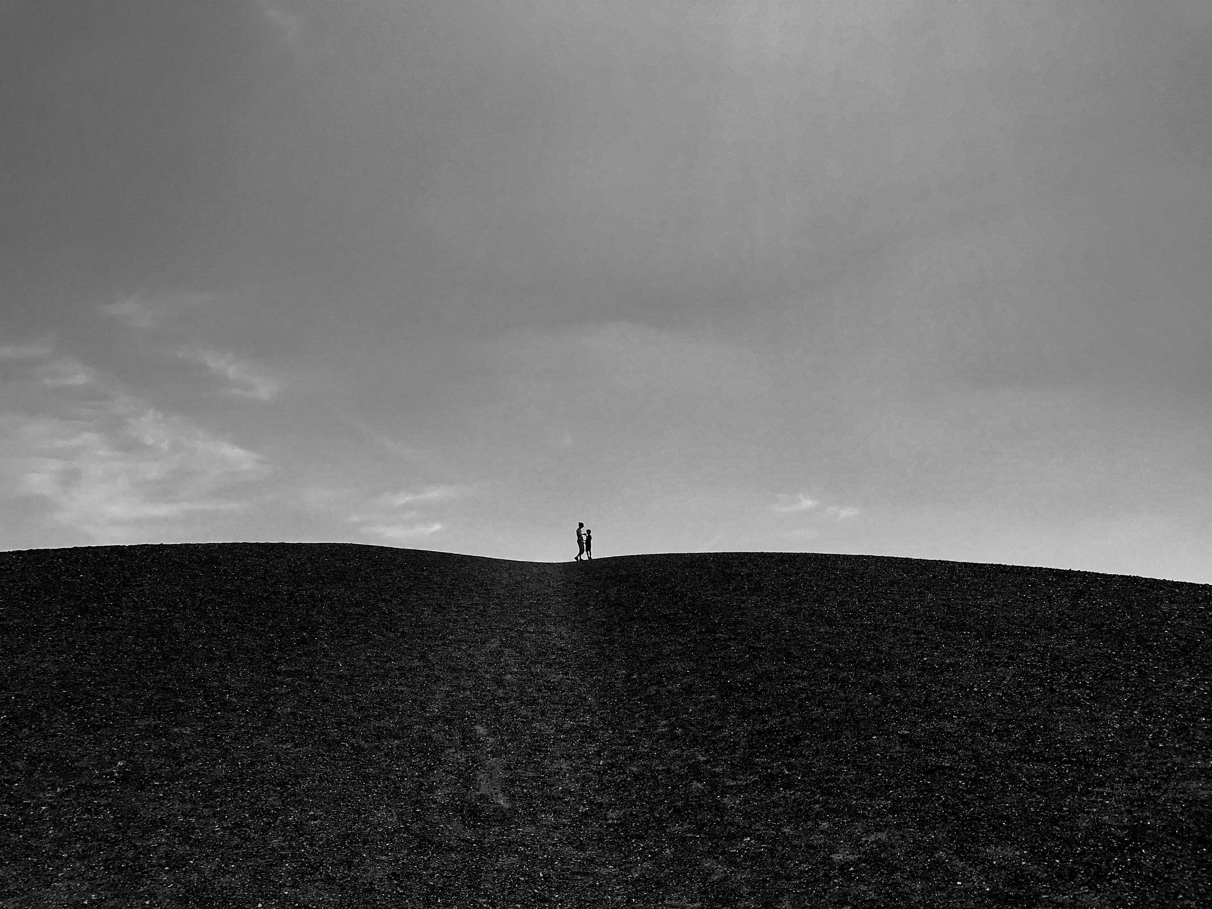 grayscale photo of person standing on the field