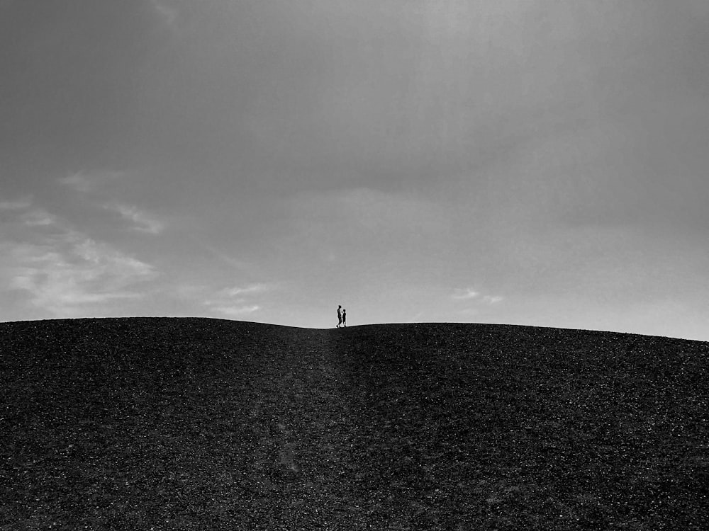 grayscale photo of person standing on the field