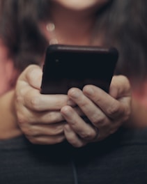 person holding black iphone 4