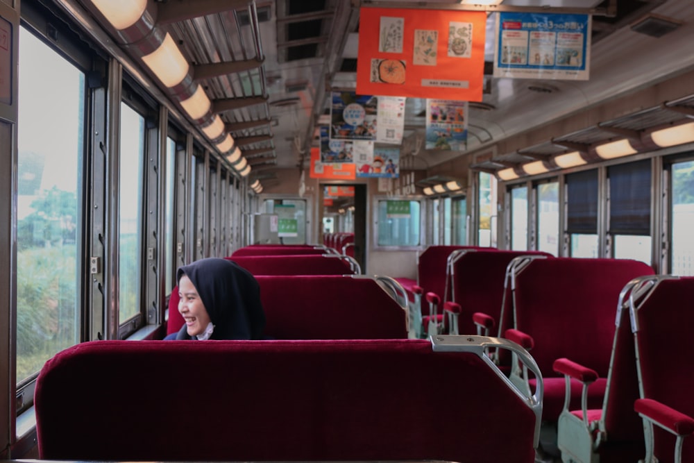 a woman sitting on a train looking out the window