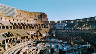 A gladiator arena filled with cheering crowds under a bright sky.