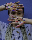a woman with painted hands covering her face