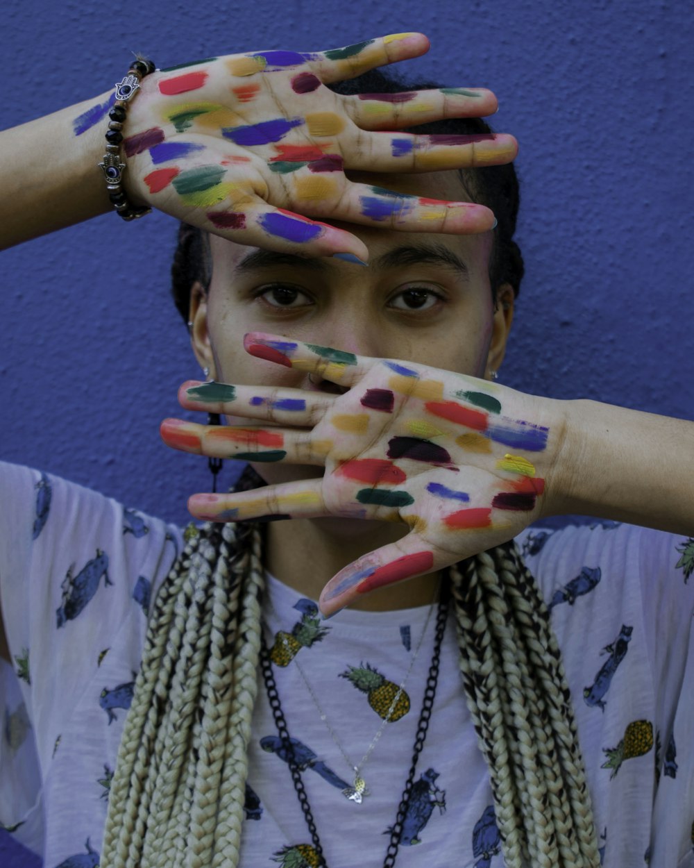 Una mujer con las manos pintadas cubriendo su rostro