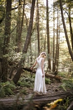 woman in white dress standing on forest during daytime