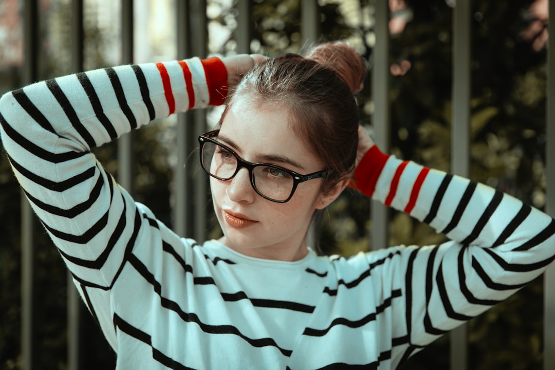 woman in black and white striped long sleeve shirt wearing black framed eyeglasses