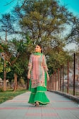 woman in green and white dress standing on gray concrete pathway during daytime