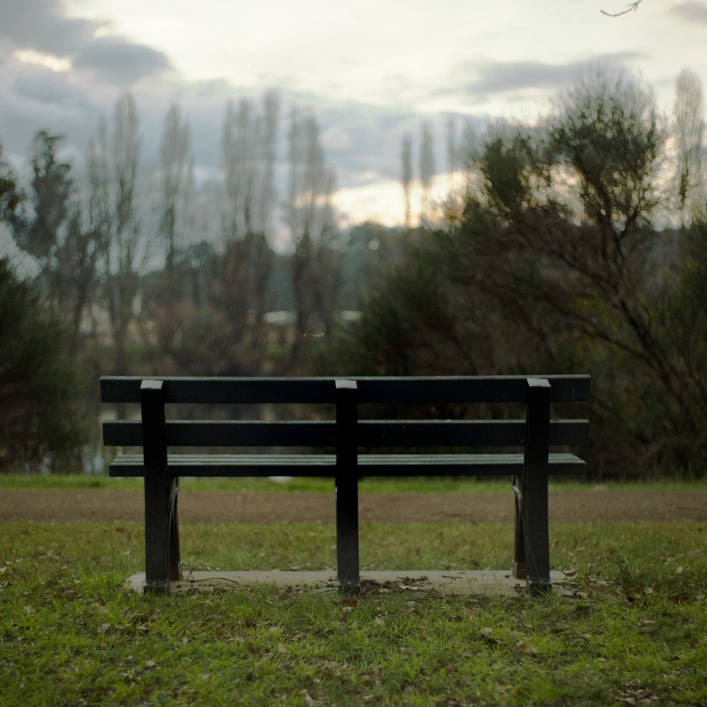 brown wooden bench near trees during daytime