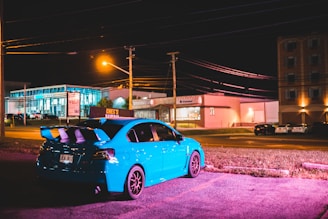 Nighttime photo of a car parked with blue LED lights highlighting the blue wrap lines.
