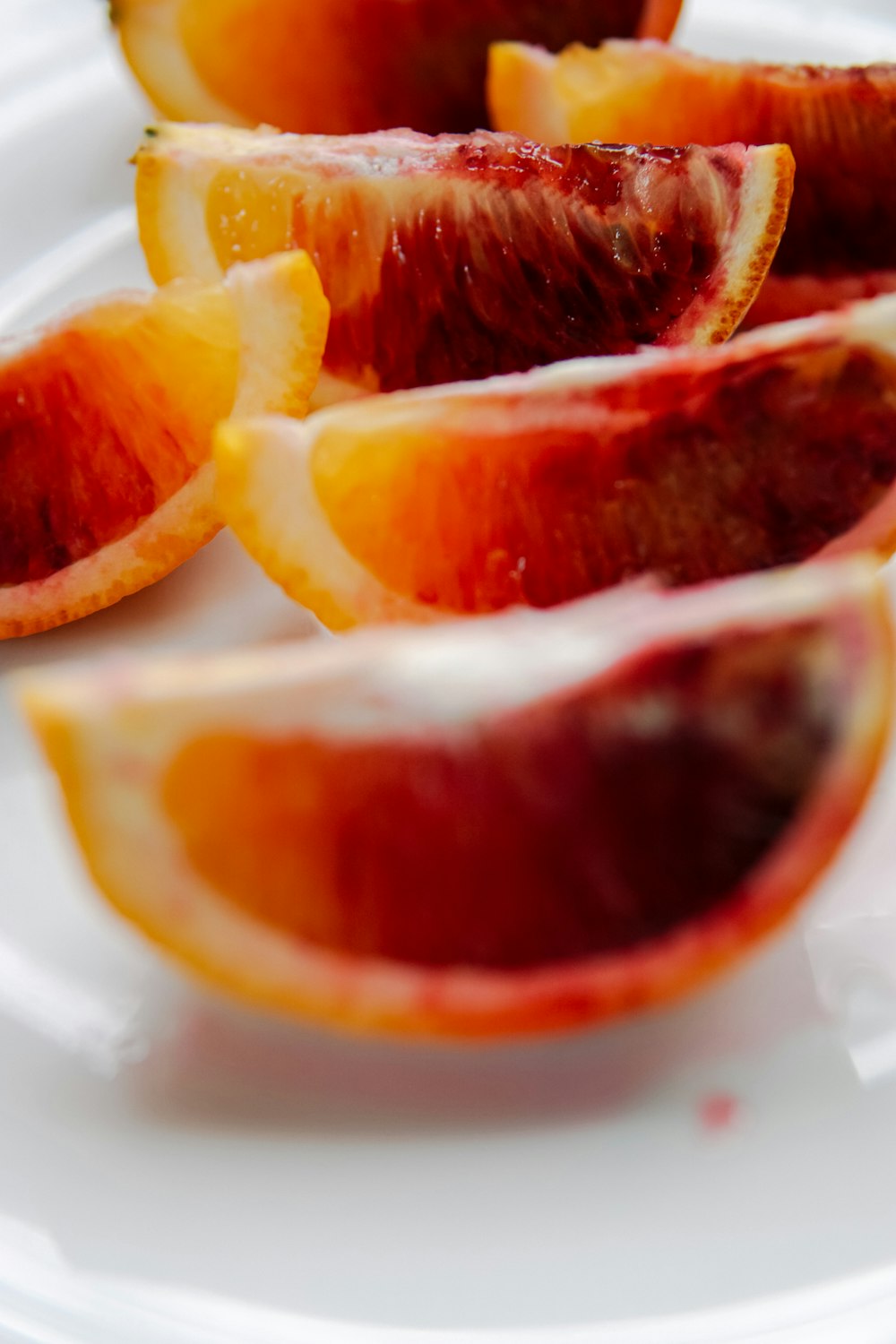 Frutta arancione a fette su piatto di ceramica bianca