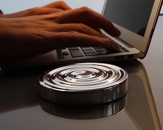 Hands typing on a laptop with symbolic patterns in the background.