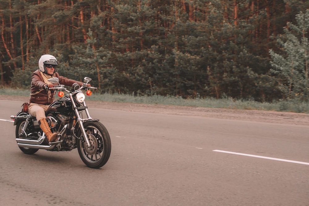 homme conduisant une moto sur la route pendant la journée