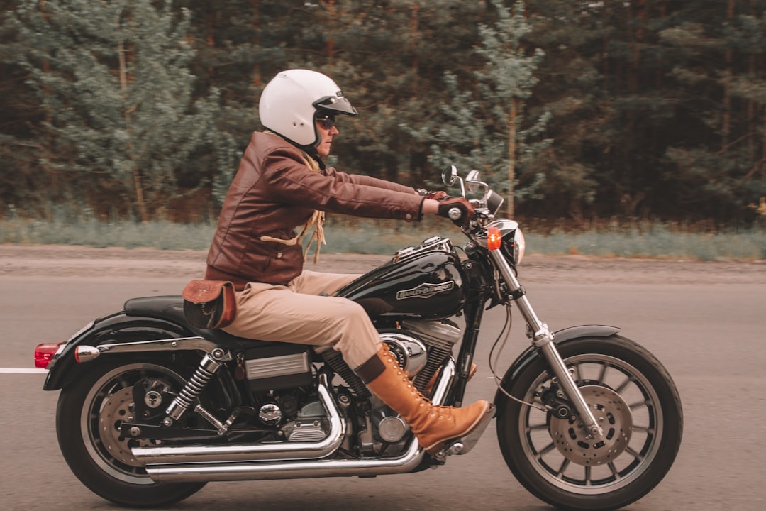 man in brown leather jacket riding on black motorcycle during daytime