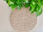 Woven jute table mats laid out on a farmhouse dining table with natural light.
