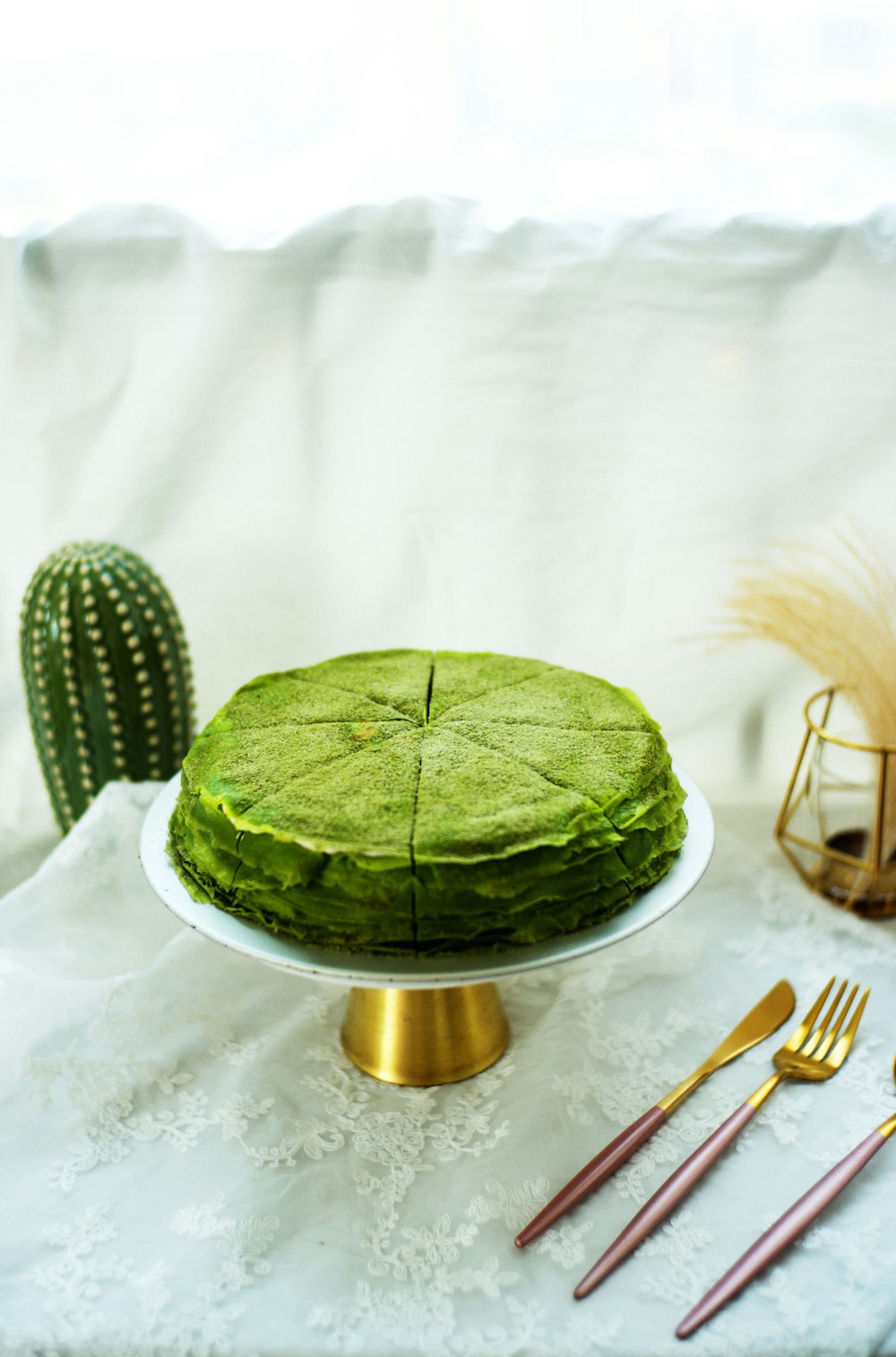 a green cake sitting on top of a white table