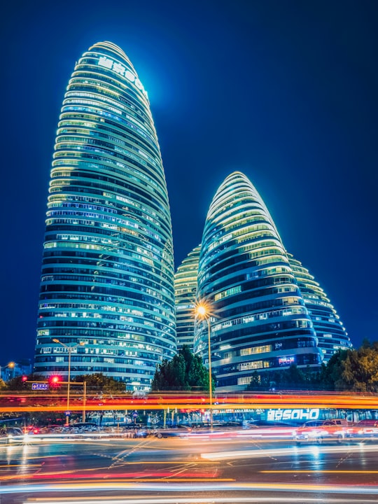 green and blue lighted building during night time in Wangjing SOHO China