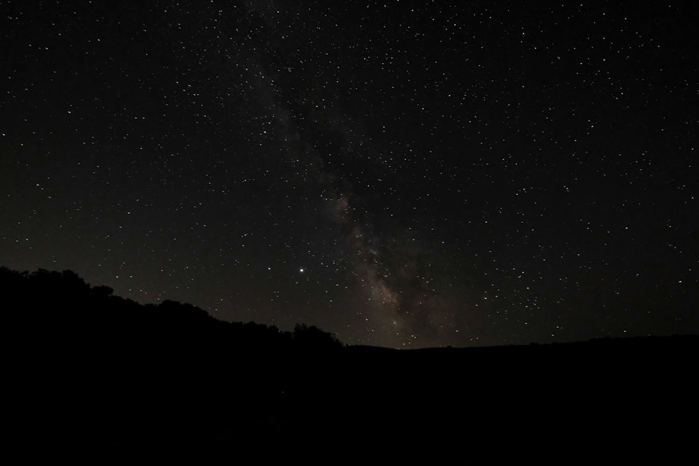 silhouette of mountain under starry night