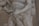 A detailed close-up view of a marble sculpture depicting a dynamic and intricate scene featuring human figures. The focus is on the interlocking hands and muscular arms, emphasizing the tension and movement captured in the stone.