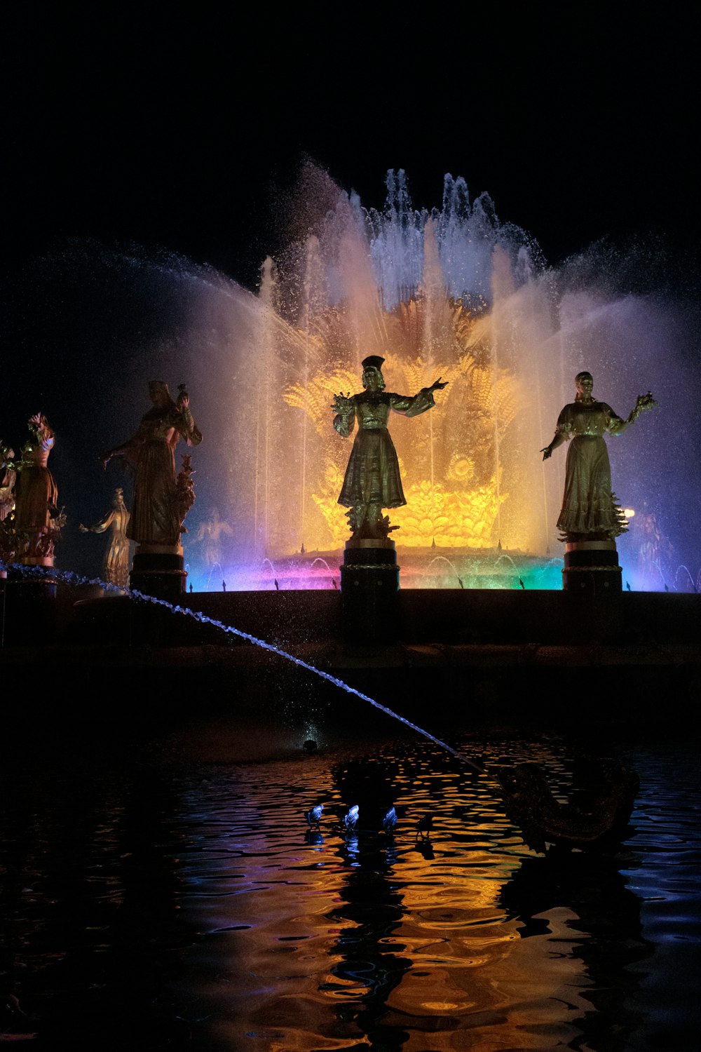 water fountain with lights turned on during night time