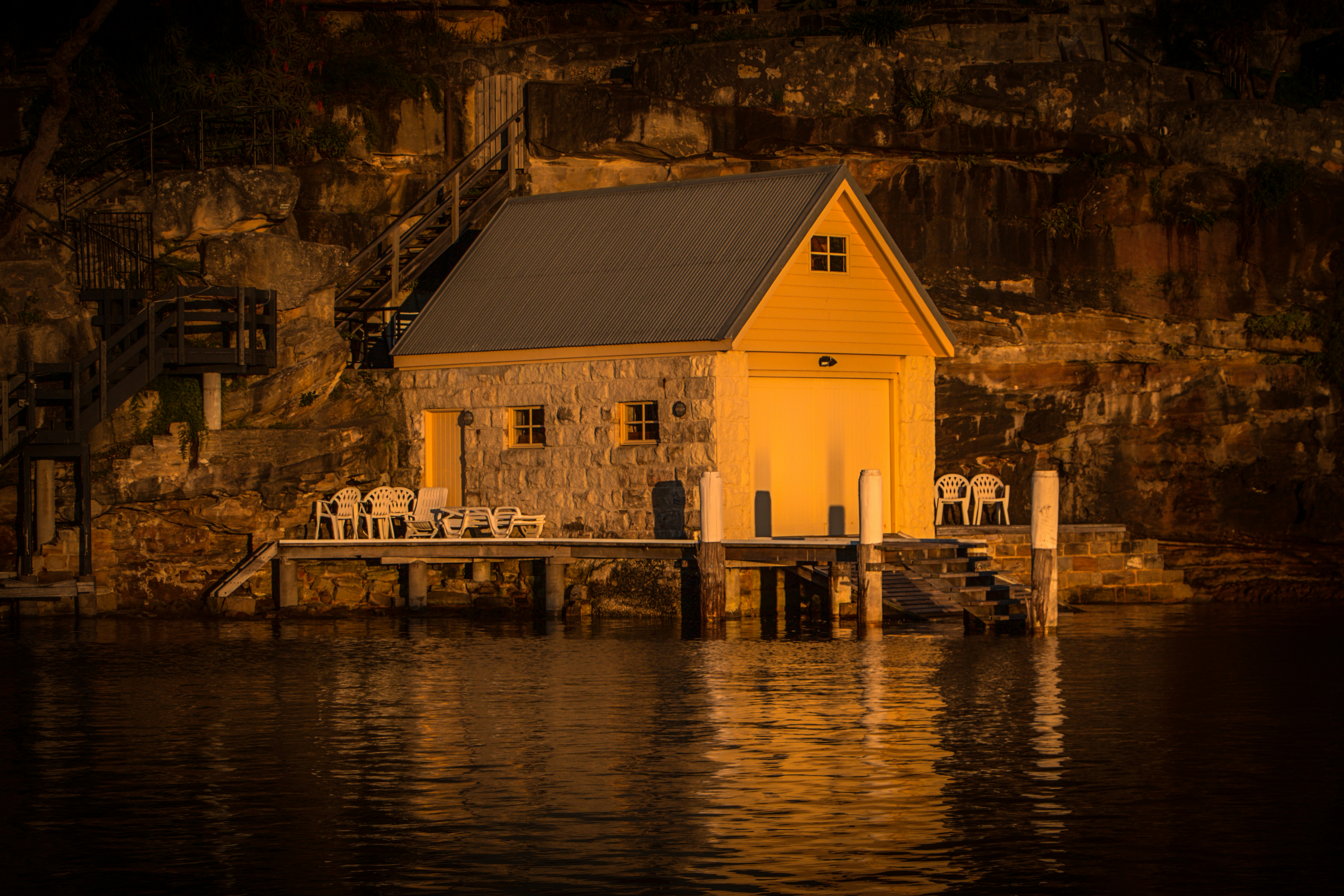 white and brown wooden house near body of water during daytime