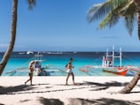 woman in pink bikini walking on beach during daytime