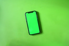 A sleek smartphone showing a custom app interface with green and gold accents.