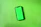 Close-up of a smartphone showing a green-accented modern landing page on the screen.