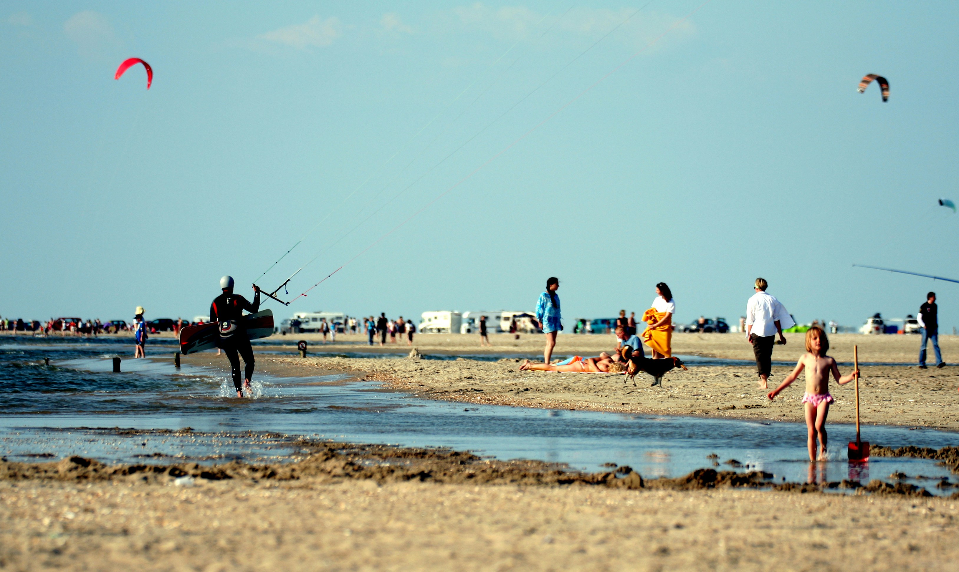 Orang-orang bermain bola basket di pantai pada siang hari