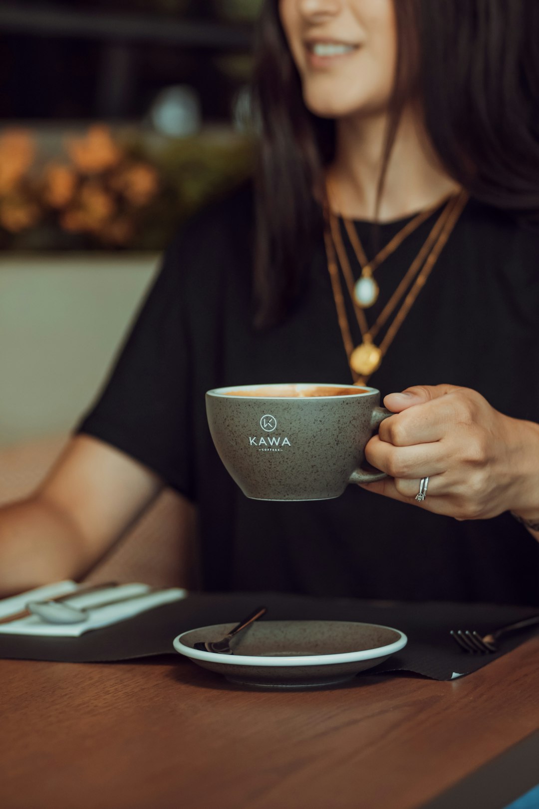 woman in black shirt holding gray ceramic mug