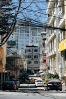 cars parked on side of the road in between buildings during daytime