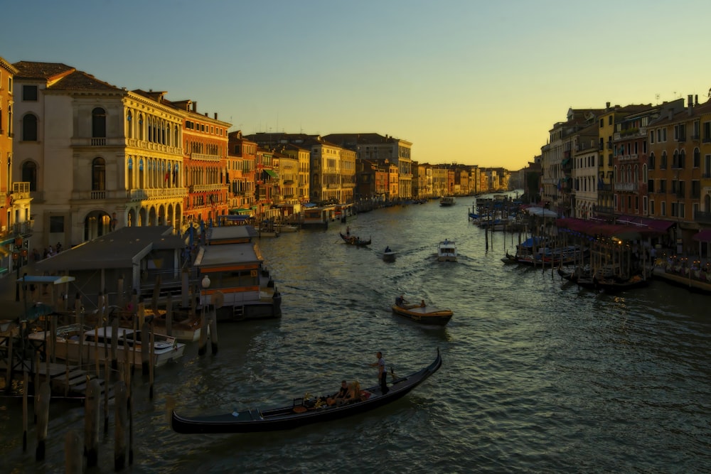 a canal filled with lots of boats next to tall buildings