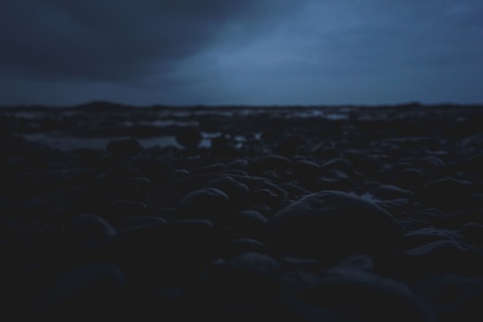 black rocks on the beach during night time in Daman India