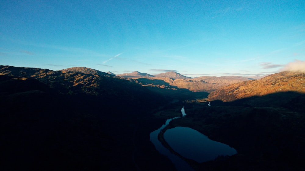 lake in the middle of mountains during daytime