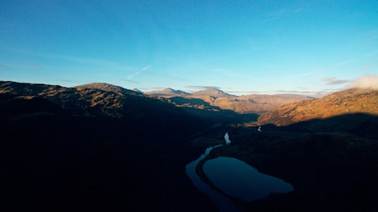 lake in the middle of mountains during daytime in Scotland United Kingdom