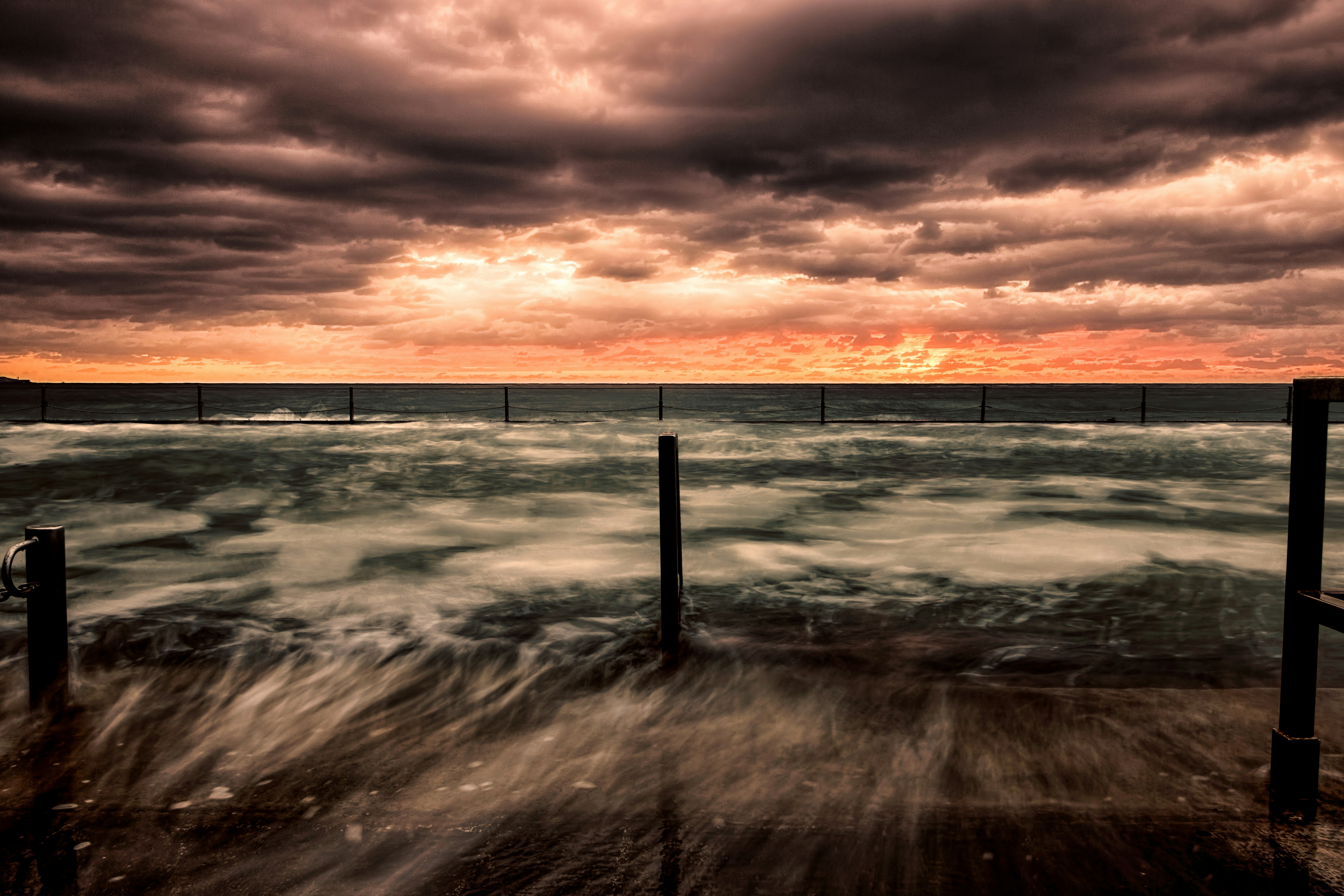 sea waves crashing on shore during sunset