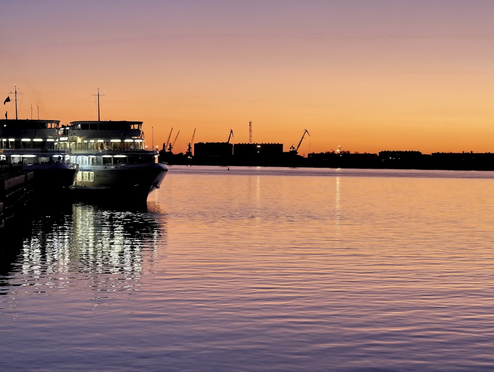 silhouette of boat on sea during sunset