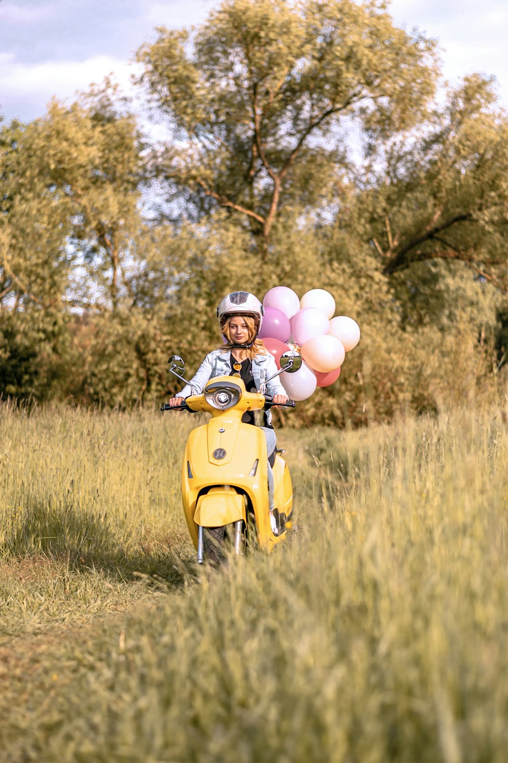 Ballons blancs et roses sur scooter jaune