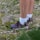 Hiker wearing wool socks standing on a rocky trail with mountains in the background.