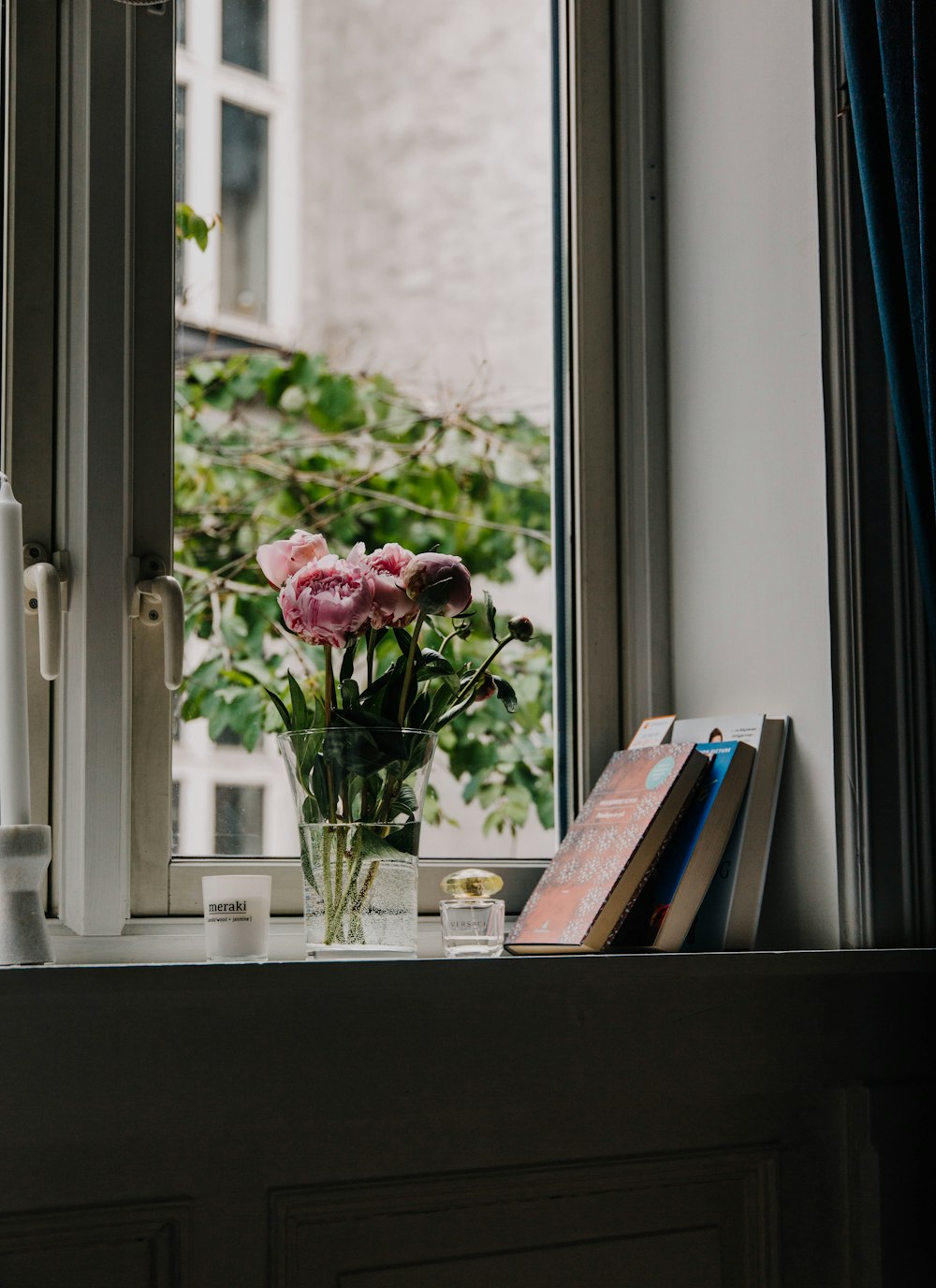 Roses roses dans un vase en verre transparent sur une table en bois blanc