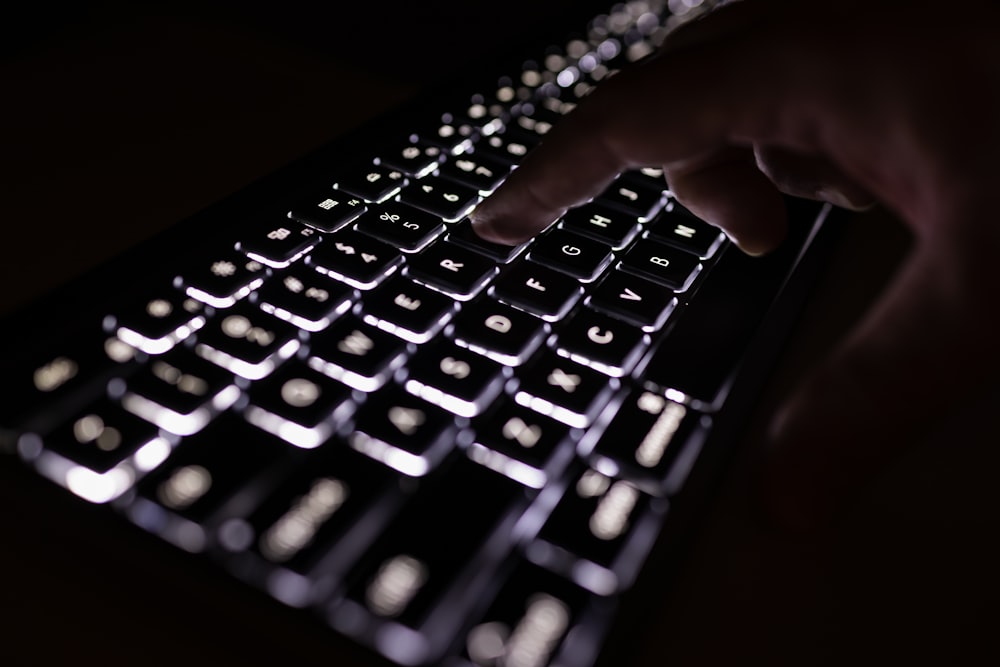 person holding black computer keyboard