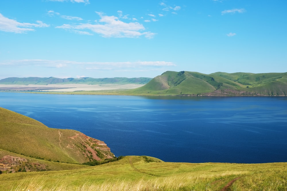 green mountain beside blue sea under blue sky during daytime