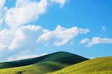 A serene landscape showcasing lush green hills and clear blue skies.