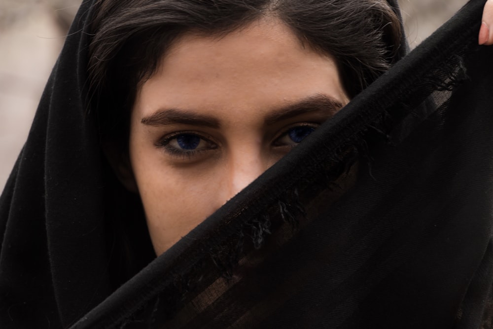 womans face on black textile