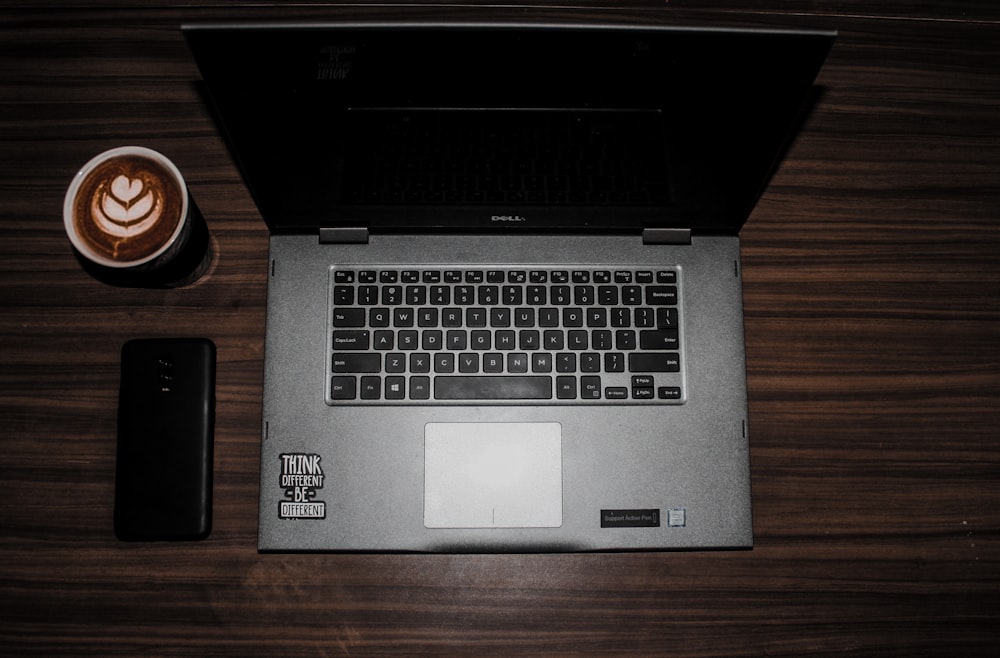 black and silver laptop computer on brown wooden table