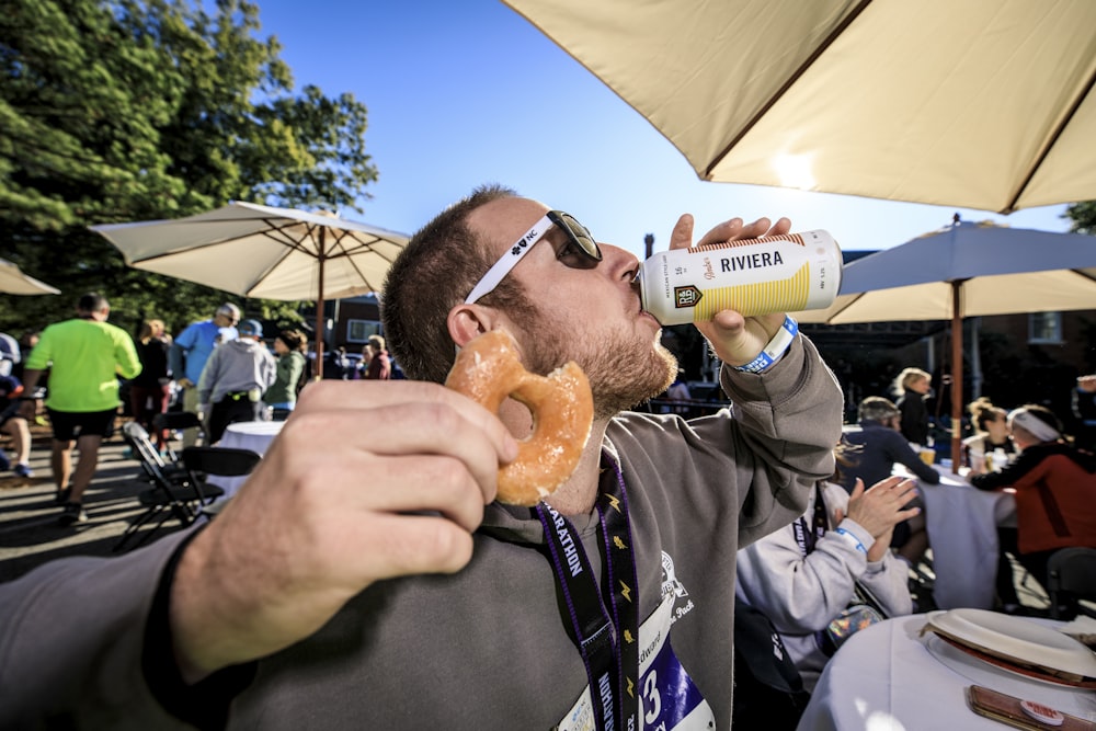 man in gray jacket holding white plastic bottle