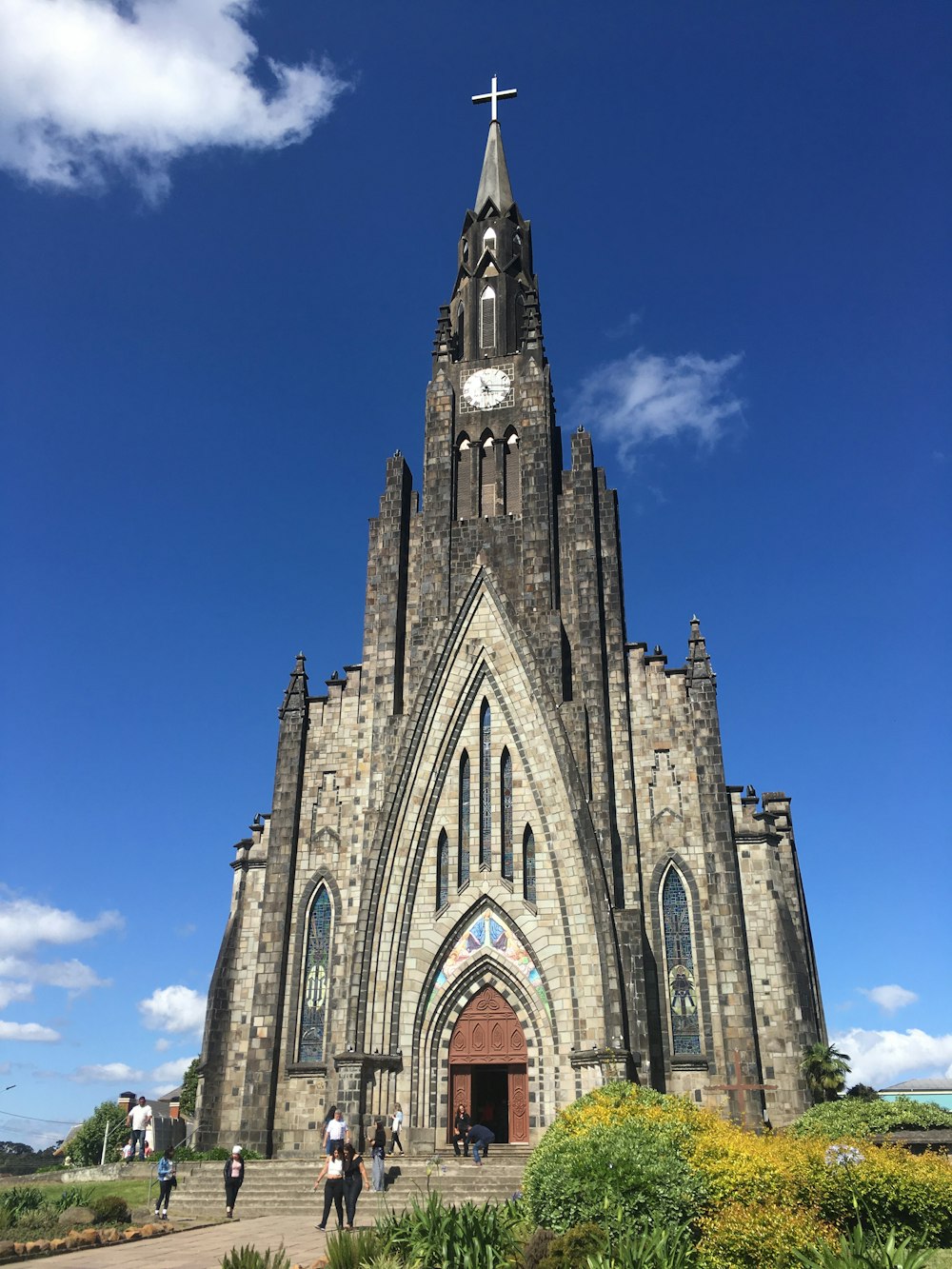 昼間の青空に覆われた灰色のコンクリートの教会