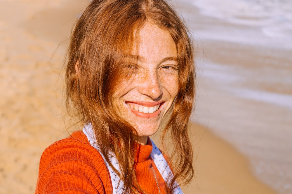 mujer en suéter de punto rojo sonriendo