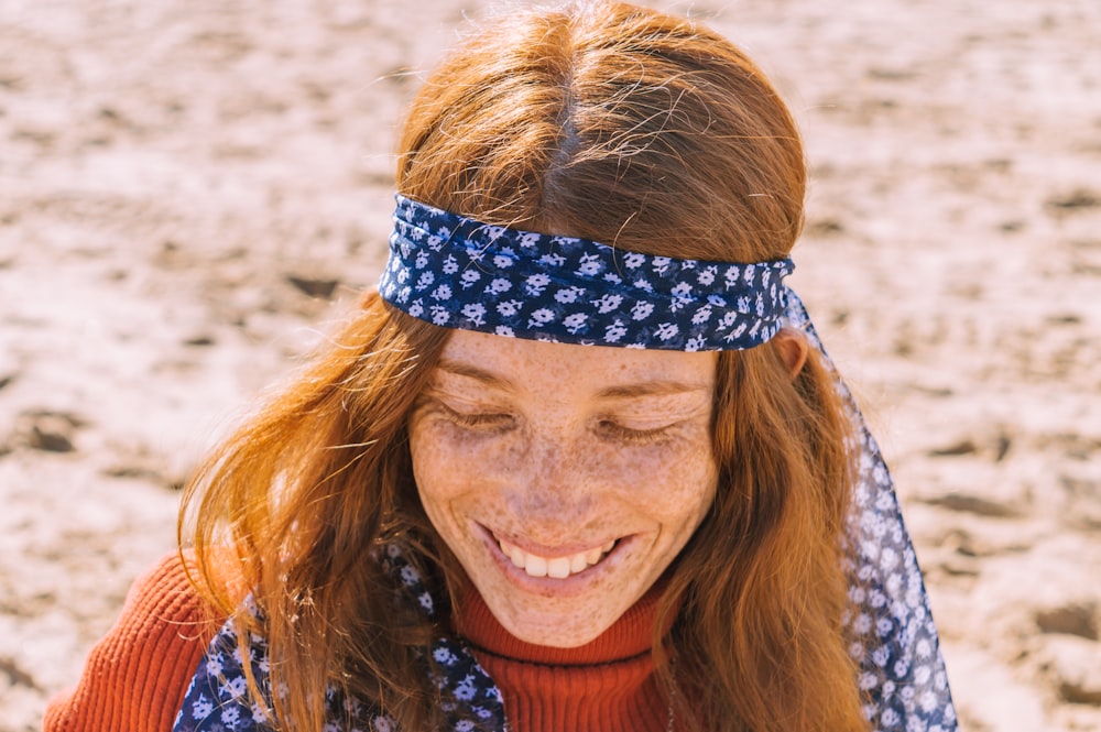 woman in orange shirt wearing blue and white head band
